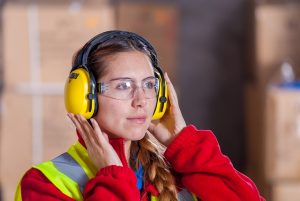 Woman wearing high visibility jacket and personal protective equipment