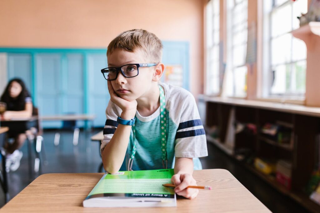 Young boy thinking.  From Pixabay - https://www.pexels.com/photo/a-boy-wearing-eyeglasses-in-the-classroom-8500611/