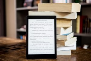 Ebook reader leant against a pile of books