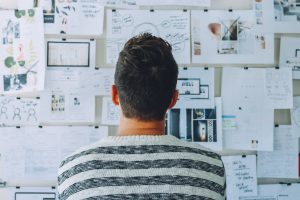 Man staring at crammed noticeboard