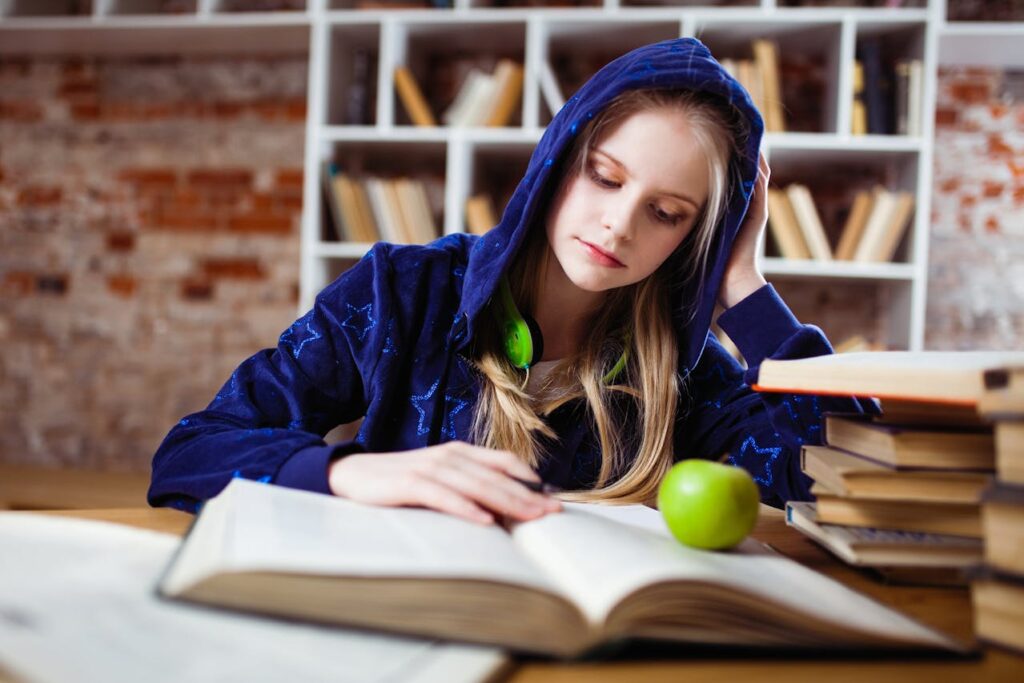 Woman studying.  From Pexels - https://www.pexels.com/photo/woman-wearing-blue-jacket-sitting-on-chair-near-table-reading-books-1326947/