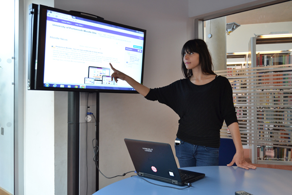 Woman presenting from a plasma screen in a library group study room