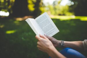 Woman reading a book outdoors.  From Pixabay - https://pixabay.com/photos/book-woman-park-read-reading-1835799/