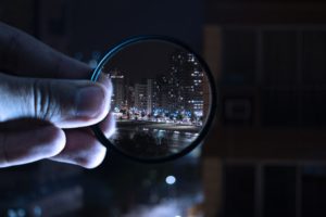 Magnifying glass bringing cityscape into sharp definition