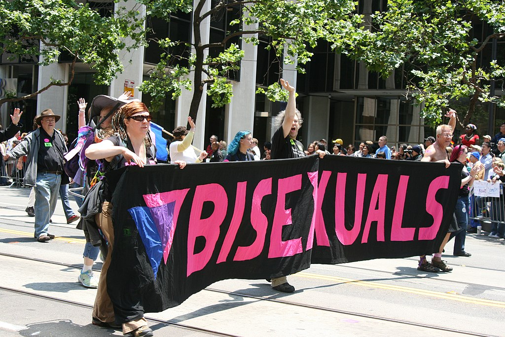 Members of a Pride parade carrying a banner reading "bisexuals".