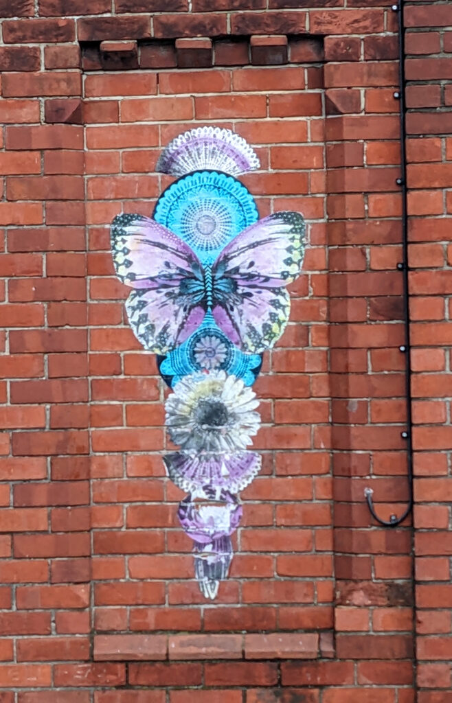 A cone comprising butterflies, fans and flowers in blues and purples.  Artist unknown.