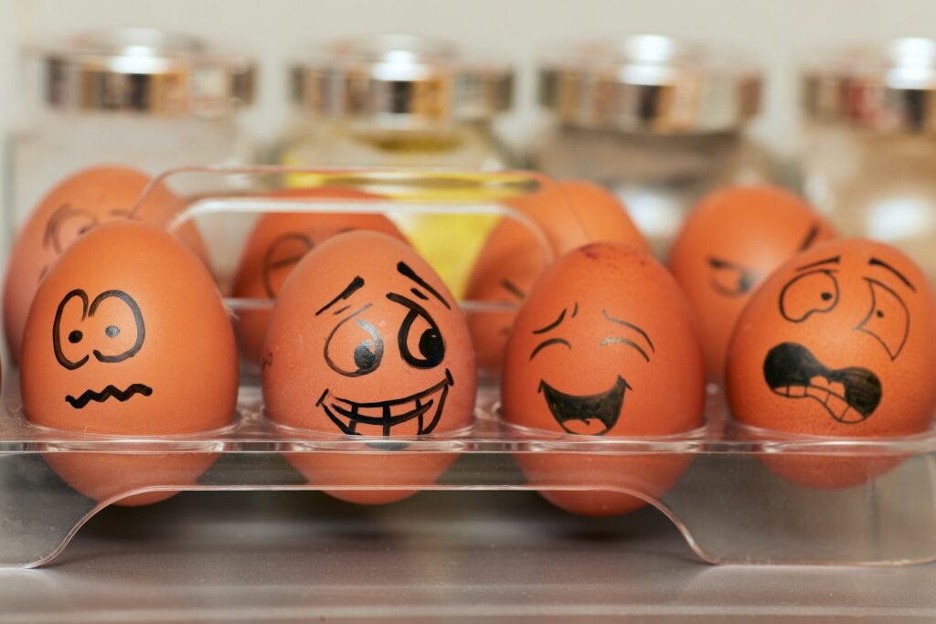 Eggs with comical expressions representing different emotional reactions drawn on in black pen