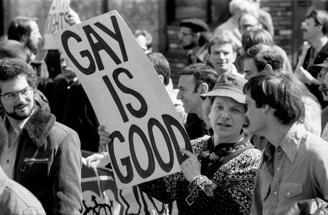 Gay rights rally (ca. 1970s).  Man centred is holding up a placard reading "Gay is good".